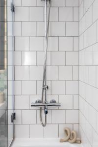 伦敦Luxury & Spacious 2 BR APT with City Views的浴室铺有白色瓷砖,设有淋浴。