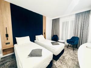 波亚纳布拉索夫Hotel Soimul的酒店客房设有两张床和蓝色的墙壁。