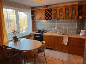 萨拉茨格里瓦Family house room的厨房配有木制橱柜、桌子和桌椅