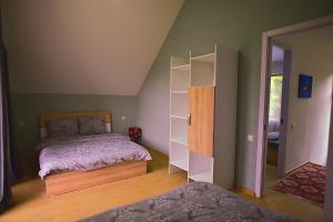 博尔若米Chalet Resort Weekend Borjomi的一间卧室设有一张床和一个书架