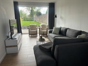 拉纳肯Vakantiehuis ViDa的客厅配有沙发、椅子和电视