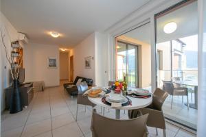 马卡尼奥Vista di Maccagno Fantastico Pool的用餐室以及带桌椅的起居室。