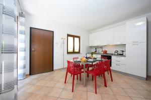 拉韦诺-蒙贝洛Le Betulle Garden in Laveno的一间厨房,里面配有桌子和红色椅子