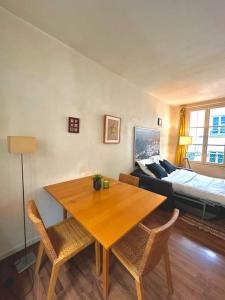 巴黎Cozy 1BR in the Heart Of Paris的客厅配有桌椅和1张床