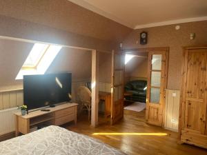 萨拉茨格里瓦Family House Apartments的一间卧室配有一张床和一台大屏幕电视