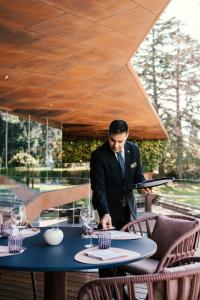 加尔达湖滨Lido Palace - The Leading Hotels of the World的站在桌子上的穿着西服的人
