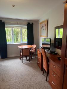 科克Fernhill Lodge Carrigaline的客厅配有桌椅和电视。