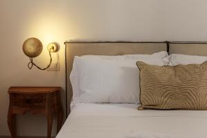 诺托Embrace Sicily Guest House的一张带白色枕头的床和一张桌子上的台灯