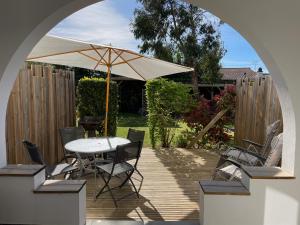 滨海圣帕莱Vacances Sur Mer的庭院配有遮阳伞和桌椅。