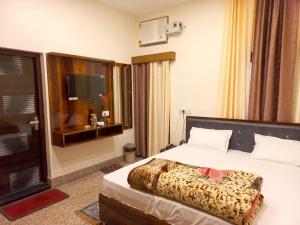 AyodhyaKalash Guest House的酒店客房,配有床和电视