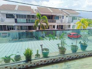 怡保perdana homestay的建筑里种植了盆栽植物的阳台