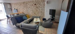 瓦朗索尔La Provençale ..的客厅配有沙发、椅子和电视