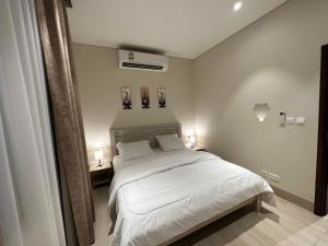 塞拉莱Wonderful Ground Studio - Hawana Salalah Resort的卧室配有白色的床和2个床头柜