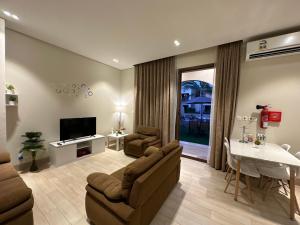 塞拉莱Wonderful Ground Studio - Hawana Salalah Resort的带沙发、电视和桌子的客厅
