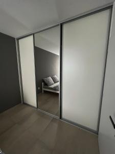 日利纳Apartmán Melissa的一间设有滑动玻璃门的房间,里面配有沙发