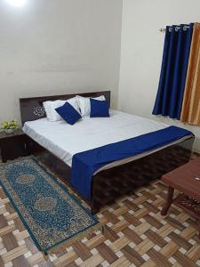 AyodhyaMahadev Kripa sadan Homestay & Guest house的一间卧室配有一张带蓝色枕头的床。