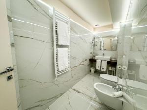 代森扎诺-德尔加达维托里奥酒店的白色的浴室设有水槽和卫生间。
