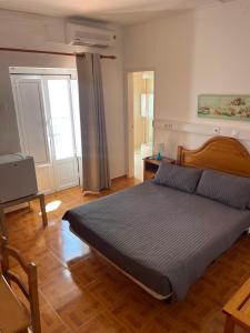 拉戈斯Pensão Dona Ana - Residencial的一间卧室配有一张床、一张桌子和一个窗户。