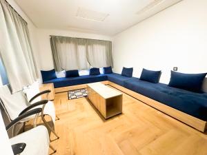 艾兹鲁AUBERGE JOMANA PARK的客厅配有蓝色的沙发和桌子