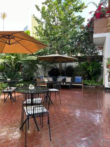 利马Lima 18 Boutique的一个带桌椅和遮阳伞的户外庭院。