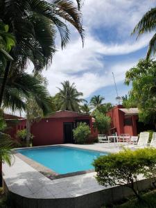 贝岛Bungalow 5 avec piscine à proximité de la plage的棕榈树屋前的游泳池