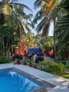 贝岛Bungalow 5 avec piscine à proximité de la plage的一群摩托车停在棕榈树房子旁边