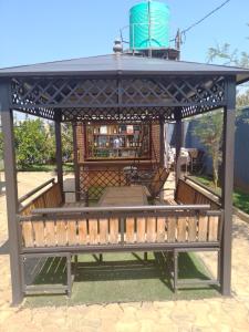 MumbwaALIJAY APARTMENTS的凉亭,带屋顶和长凳