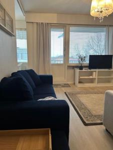 哈米纳Sibelius Kaksio Haminassa的客厅配有蓝色的沙发和电视