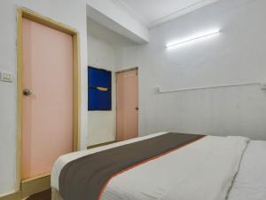 尼禄Collection O Goa Savera Holiday Homes的一间白色的房间,配有床和门