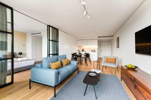 里斯本Mirabilis Apartments - LX Living的客厅配有蓝色的沙发和桌子