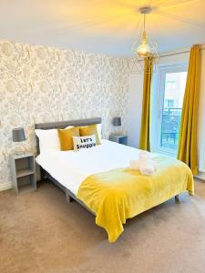 DinningtonLuxury 3 Bedroom House With FREE Parking的一间卧室配有一张带黄色毯子的大床
