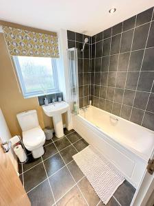DinningtonLuxury 3 Bedroom House With FREE Parking的带浴缸、卫生间和盥洗盆的浴室