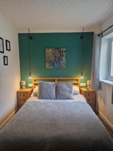 博德明Cosy Self Contained Annexe的一间卧室设有一张大床和绿色的墙壁