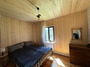 KiketʼiCozy Wooden House in Kiket'i კიკეთი的一间卧室设有一张木天花板床。