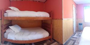 库拉考廷Cabañas & Hostal Lefuco的红色墙壁的客房内设有两张双层床。