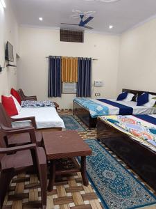 AyodhyaMahadev Kripa sadan Homestay & Guest house的一间设有两张床和一张桌子及椅子的房间