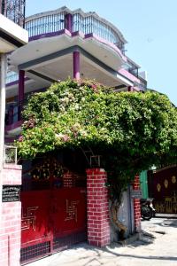 AyodhyaMahadev Kripa sadan Homestay & Guest house的一座建筑物前的灌木丛,鲜花盛开