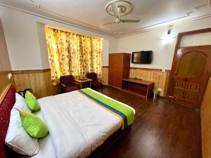马拉里Woodstock Inn Manali的酒店客房,配有床和电视