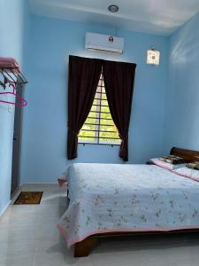 丹那美拉Homestay Haji Noor的蓝色的卧室设有床和窗户