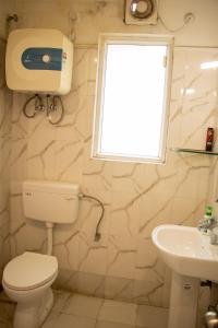 瓦拉纳西Vara的一间带卫生间、水槽和窗户的浴室