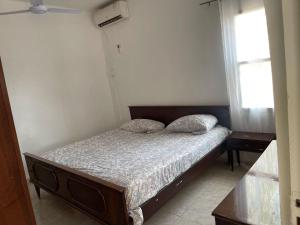 SukutaSamba Tako Plaza Home Suites的一间卧室设有一张床和两个窗户。