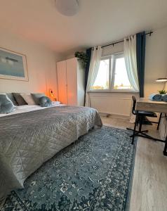 马尔默Central Peaceful Villa, Malmö的一间卧室配有一张床、一张书桌和一个窗户。