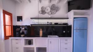 KlimaFisherman House的厨房配有白色橱柜和蓝色冰箱。