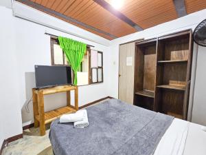 卡利La Mercedes Lite Hostal By MH的一间卧室配有一张床和一台电视。