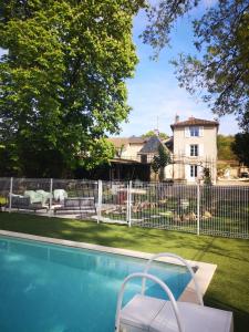沙斯讷伊迪普瓦图LE REPAIRE gîte 4 étoiles的一座游泳池,位于围栏前,设有一座房子