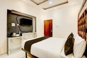 瓦拉纳西Super OYO Flagship SHIVA VALLEY HOTEL的一间卧室配有一张大床和电视