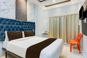 瓦拉纳西OYO Flagship SHIVA VALLEY HOTEL的一间卧室配有一张大床和蓝色床头板