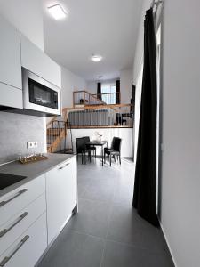 格拉茨Grazora Living Apartments的厨房配有白色橱柜和桌椅