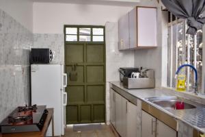 KiambuMella homes limuru的厨房设有绿门和白色冰箱。