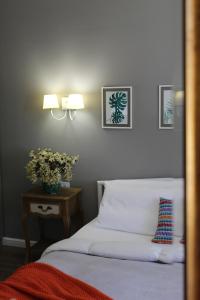都拉斯Vala Mar Apartament的一间卧室配有一张床和一张鲜花桌